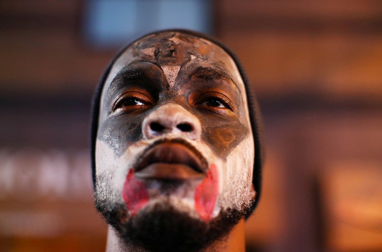 Image: A protester with a painted face joins the demonstrations during another night of protests over the police shooting of Keith Scott in Charlotte