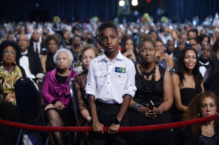 Image: A young boy listens to President Barack Obama as he speaks at the Congressional Black Caucus Foundation