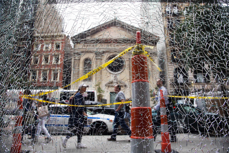 Image: New Yorkers pass a shattered storefront window on W. 23rd St. in Manhattan