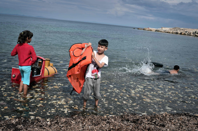 Image: Children play on the beach at an unofficial refugee site run by activists on the island of Lesbos
