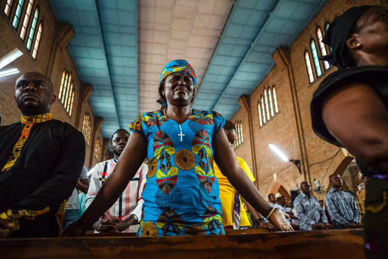 Image: A woman cries as she attends a Catholic mass in Kinshasa