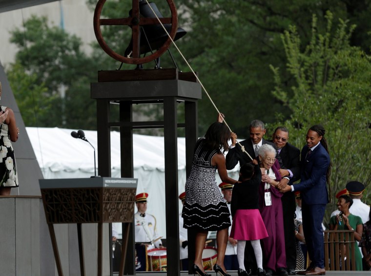 Image: U.S. President Barack Obama with First Lady Michelle Obama and the Bonner family ring the onstage bell during dedication and grand opening of the Smithsonian Institution's National Museum of African American History and Culture in Washington
