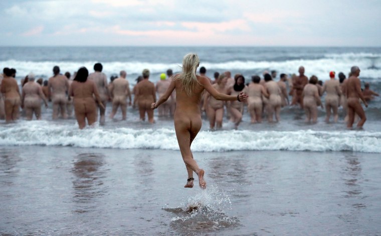 Image: Participants in the annual North East Skinny Dip run into the sea at Druridge Bay
