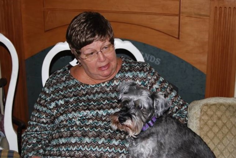 Louann VanKoevering holds one of her miniature schnauzers on her lap.