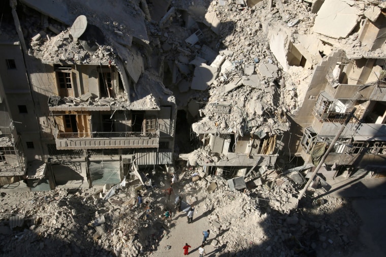Image: People dig in the rubble in an ongoing search for survivors at a site hit previously by an airstrike in the rebel-held Tariq al-Bab neighborhood of Aleppo