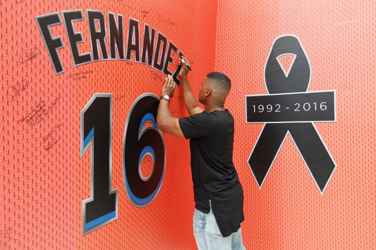 Image: A fan signs the memorial mural as he mourns the death due to a boating accident of Miami Marlins pitcher Jose Fernandez, outside Marlins Park prior to a game against the New York Mets in Miami