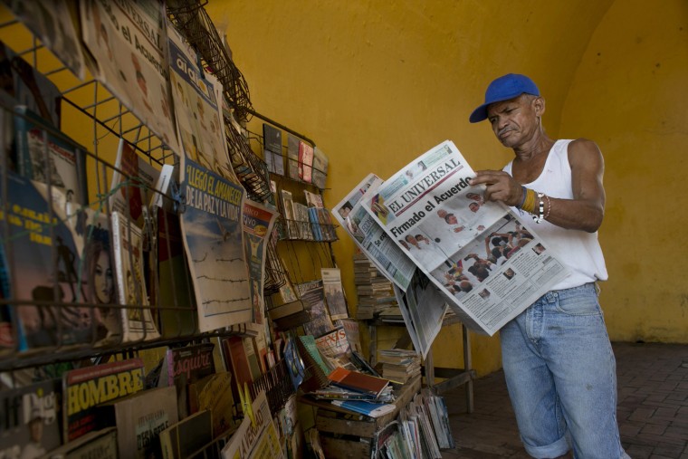 Saul Lambis reads a newspaper carrying the headline in Spanish "Agreement Signing" in Cartagena, Colombia, Tuesday, Sept. 27, 2016.