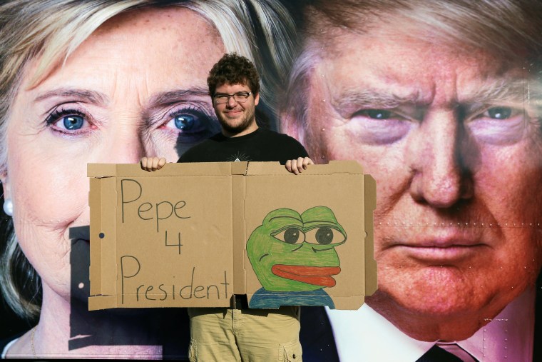 Image: Ben Wilke, 19, poses outside the first presidential debate with a sign featuring Pepe the Frog. 