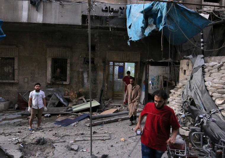 Image: Medics inspect the damage outside a field hospital in Aleppo