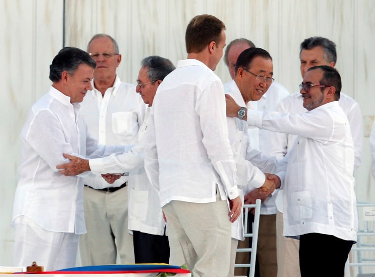 Image: Colombia's President Santos and Cuba's President Castro shake hands as UN Secretary-General Ban Ki-moon and Marxist rebel leader Londono shake hands as well in Cartagena