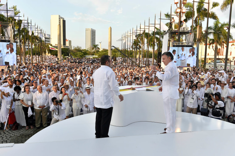 Image: Colombian President Santos and Marxist rebel leader Londono after signing an accord ending a half-century war that killed a quarter of a million people, in Cartagena