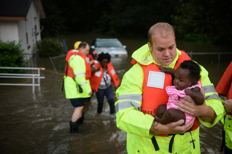 Image: Firefighters help a family out of their flooded home in Fayetteville, N.C.