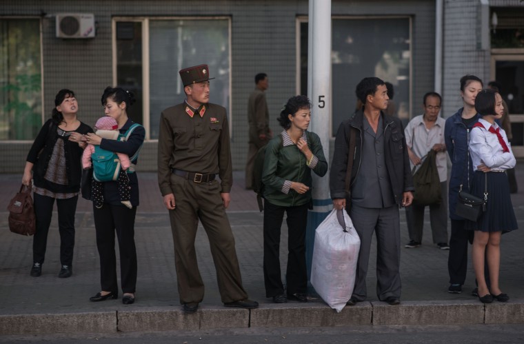 Image: Commuters wait for a bus during the morning rush hour in Pyongyang