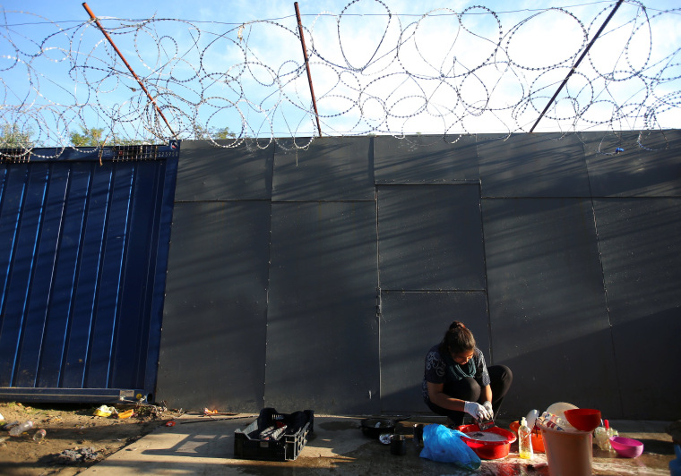 Image: A refugee woman washes clothes on the Hungary-Serbia border