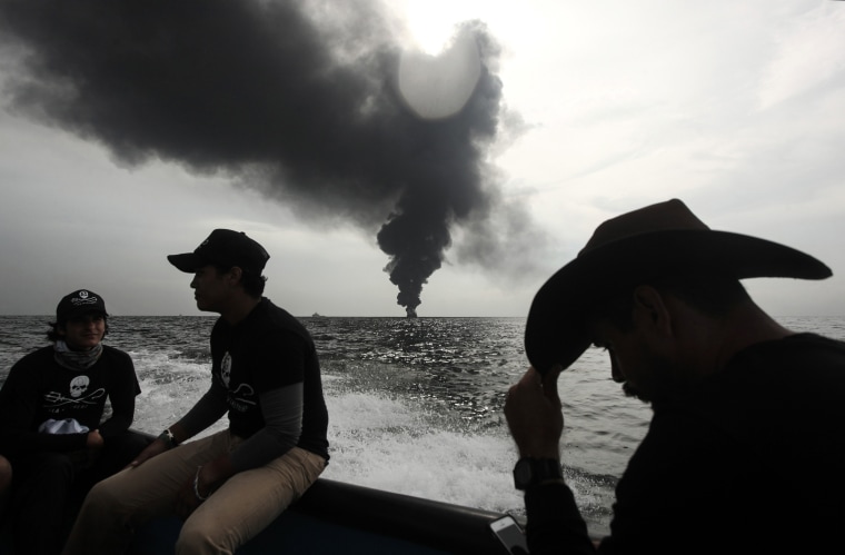 Image: Members of the marine wildlife conservation organization Sea Shepherd monitor the fuel tanker Burgos as it burns