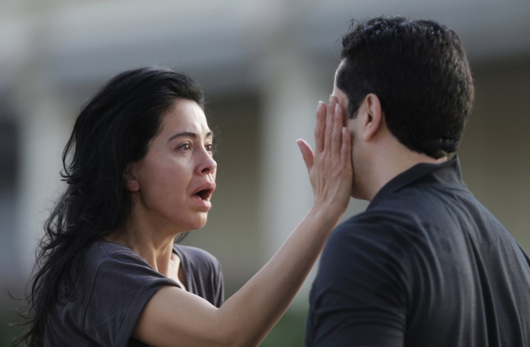 Image: Jennifer Molleda looks at the blood specked face of her husband after a shooting