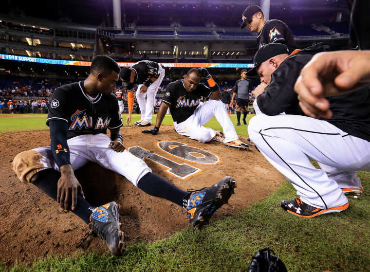 Image: Members of the Miami Marlins gather around the number of star pitcher Jose Fernandez on the pitching mound