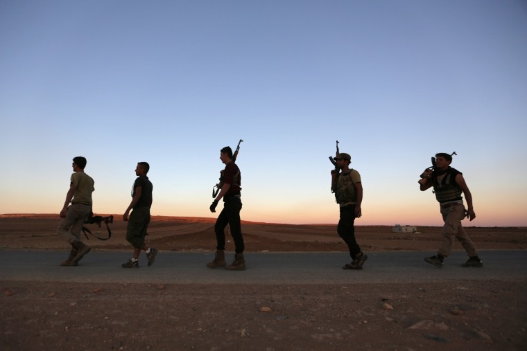 Image: Rebel fighters carry their weapons in northern Aleppo countryside