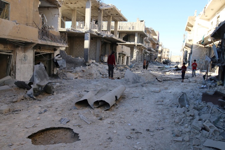 Image: People inspect a damaged site after airstrikes on the rebel held Sheikh Fares neighbourhood of Aleppo