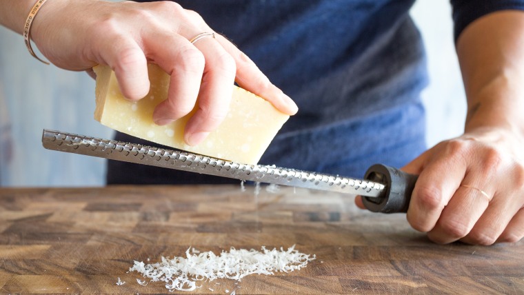 Using a Microplane to grate cheese