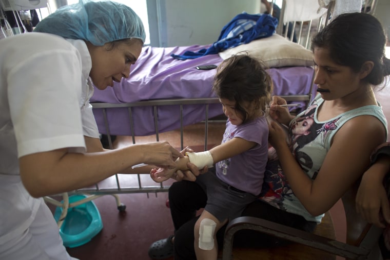 Oriana Pacheo watches intently as a nurse injects antibiotics into the arm of her 3-year-old daughter Ashley, at University Hospital in Caracas, Venezuela.