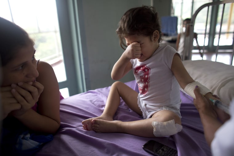 In this Aug. 24, 2016 photo, Ashley Pacheco, 3, cries as she receives an injection as her mother Oriana watches at the University Hospital in Caracas, Venezuela.