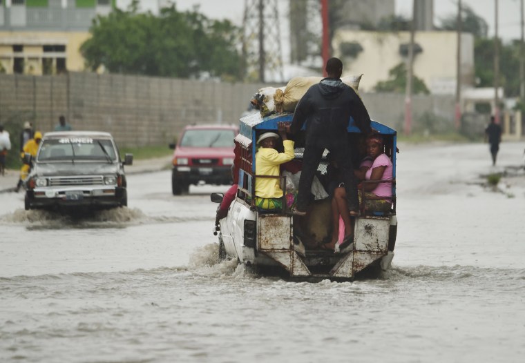 Image: A tap tap (public transportation) crosses the water left by the rain after Hurricane Matthew