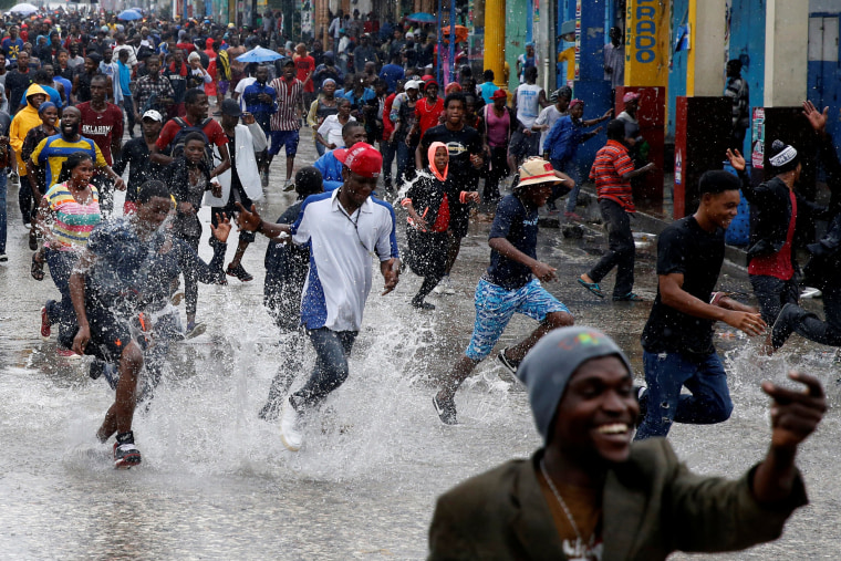 Image: Supporters of Fanmi Lavalas political party splash around in water on a flooded street as they take part in a gathering while Hurricane Matthew passes in Port-au-Prince