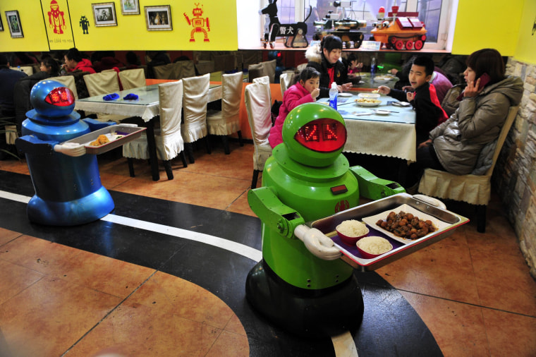 Image: Robots deliver dishes to customers at a Robot Restaurant in Harbin