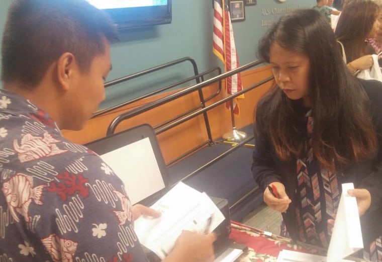 Jeffrey Tangonan Acido signs up a new citizen to vote after a U.S. Citizenship and Immigration Services swearing-in ceremony in Honolulu on June 7, 2016.
