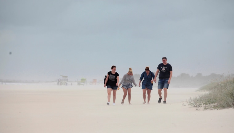 Image: People walk along the beach prior to the arrival of Hurricane Matthew in Miami Beach