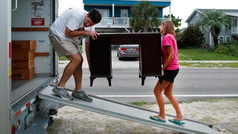 Dean Legge (L) helps his sister-law Josey Vereen (R) remove furniture from the lower level of her beachfront home along Waccamaw Drive in anticipation of Hurricane Matthew in Garden City Beach, South Carolina, U.S. October 4, 2016.