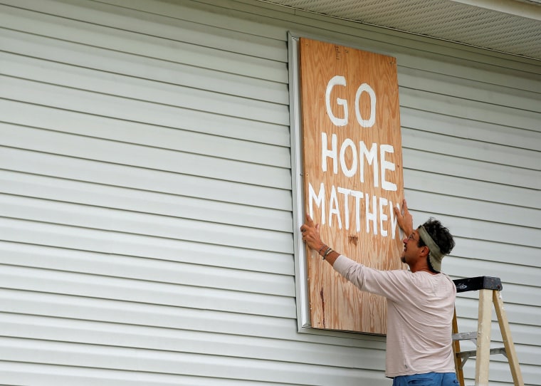 Image: Homeowner Don Appell prepares to board up one of the windows at his home ahead of Hurricane Matthew in Cherry Grove