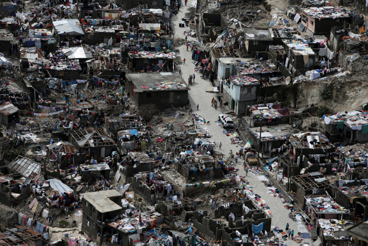 Image: People walk on a street next to destroyed houses after Hurricane Matthew hit Jeremie