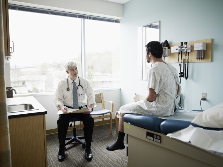 Male patient and doctor in discussion in exam room