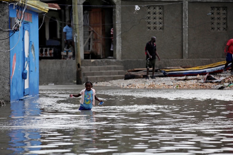 Image: A girl walks in a flooded area after Hurricane Matthew in Les Cayes