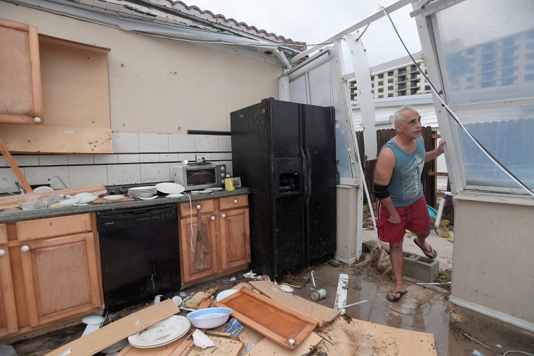 Image: Homeowner Joe Lovece surveys the damage to the kitchen at the back of his oceanfront home after the eye of Hurricane Matthew passed Ormond Beach