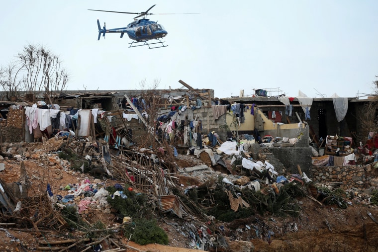 Image: A helicopter flies over destroyed houses after Hurricane Matthew passes Jeremie