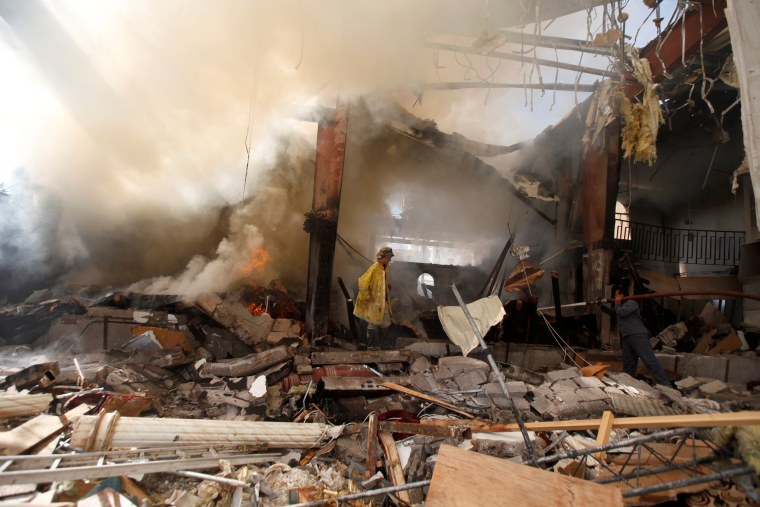 Image: Firefighters at the community hall where Saudi-led warplanes struck a funeral Saturday.
