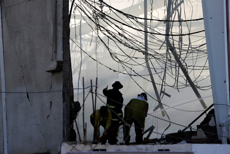 Image: Fire fighters extinguish fires after what witnesses said was an airstrike by Saudi-led coalition aircraft on mourners at a hall in Sanaa