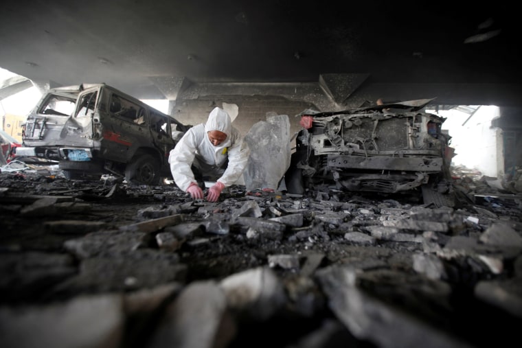 Image: Forensic expert invistigates the scene at the community hall where Saudi-led warplanes struck a funeral in Sanaa, the capital of Yemen