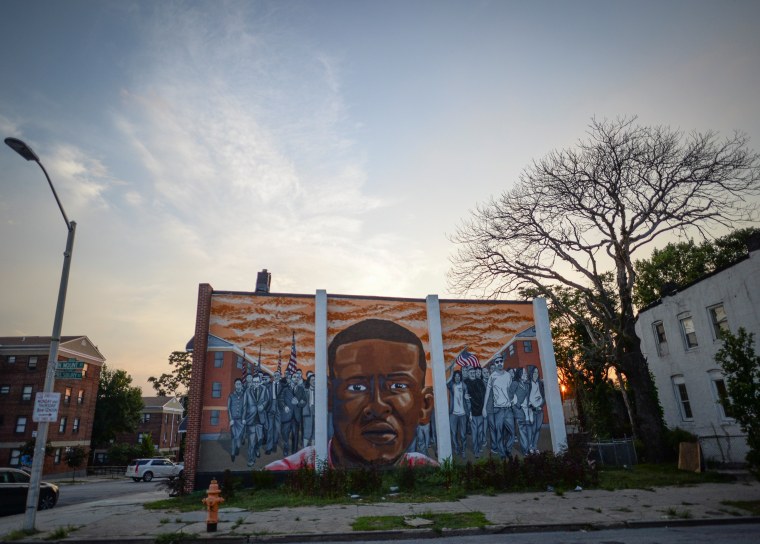 Image: The sun sets behind a mural of the late Freddie Gray in the Sandtown neighborhood of Baltimore, Maryland