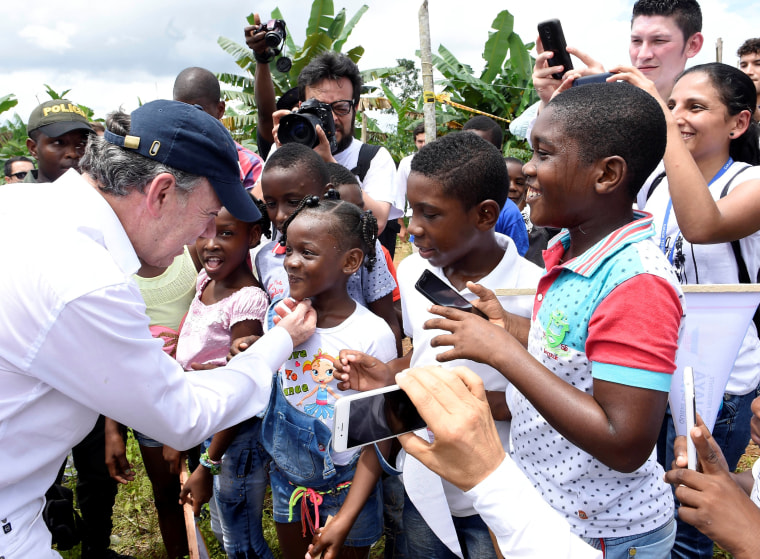 Image: Nobel Peace Prize winner Colombia's President  Juan Manuel Santos greets children after arriving  in the Bojaya area