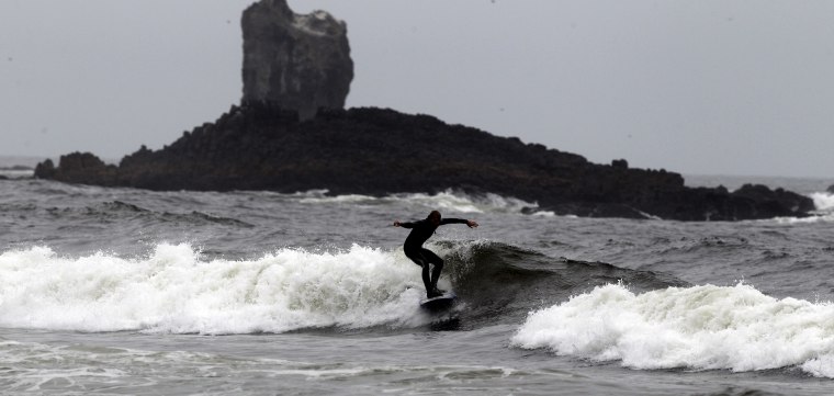 FILE: A surfer rides a wave along Indian Beach Friday, July 30, 2010, at Ecola State Park, near Cannon Beach, Ore.