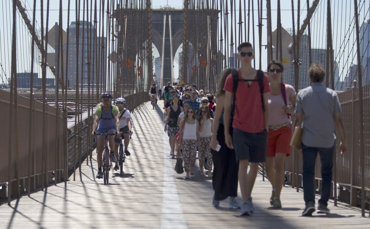 People walk and bike over the Brooklyn Bridge, June 30, in New York.