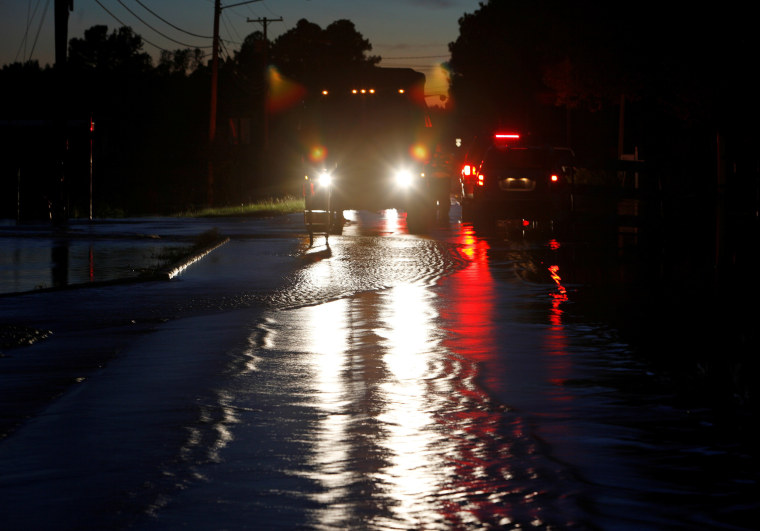 Image: Emergency vehicle lights illuminate water flowing over a road as floodwaters rise in the aftermath of Hurricane Matthew, in Lumberton, North Carolina at dusk