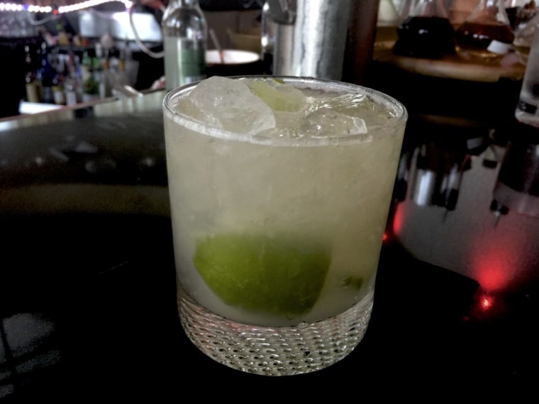 A caipirinha is a blend of cachaca, lime, and sugar, shaken with ice, then strained into a glass.