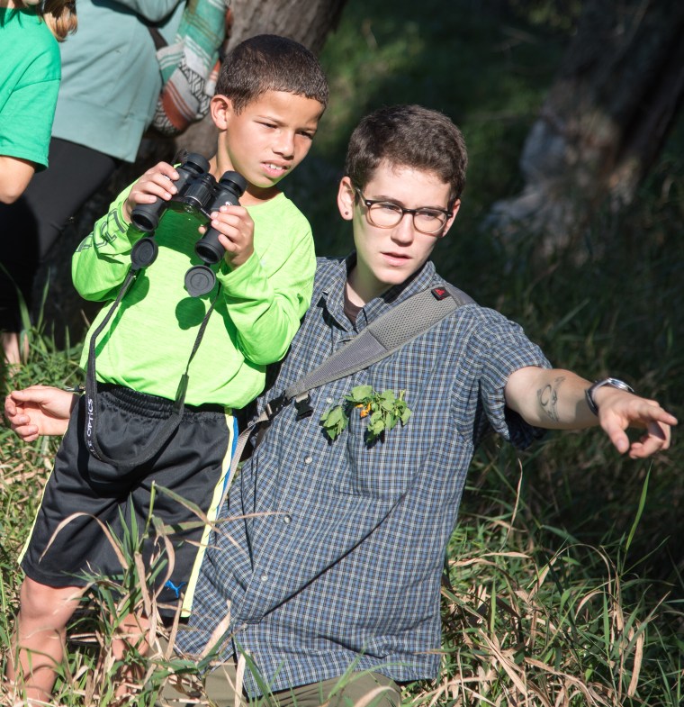 UVM senior B Freas points out a beaver in the Winooski River to Yadiel, a fifth-grader at JJ Flynn School.