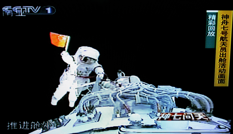 Image: Zhai Zhigang waves a small Chinese flag shortly after climbing out of the Shenzhou VII spacecraft