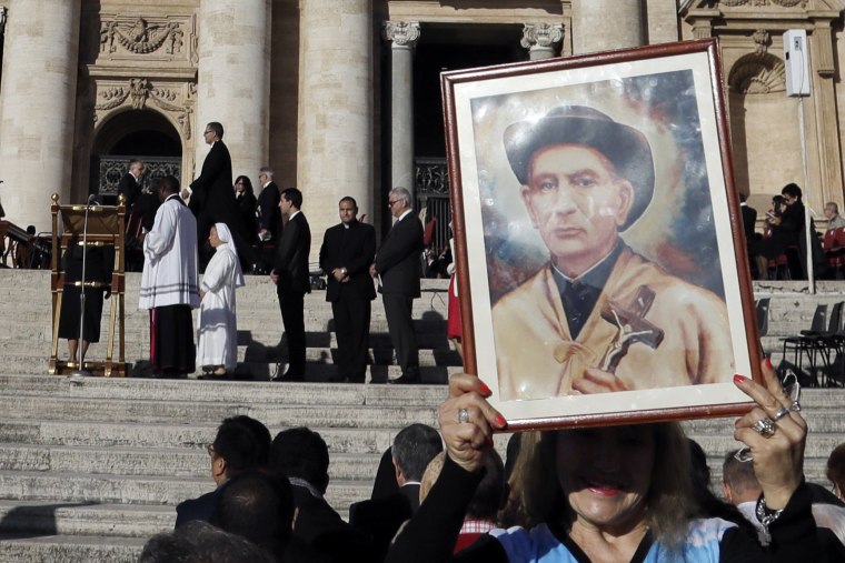 Image: A woman holds a portrait of "gaucho priest" Giuseppe Gabriele Del Rosario Brochero outside the Vatican Sunday.